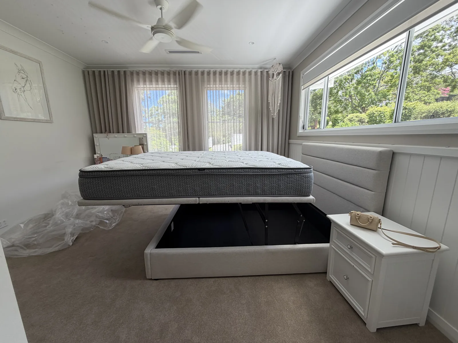 Upholstered storage bed with its base raised