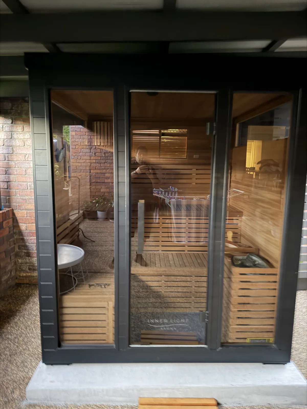 Outdoor sauna with glass doors and timber interior